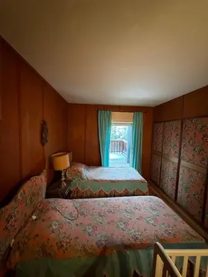 two beds in a small room with a window at Casa panoramica con terrazza vista Tofane in Cortina dʼAmpezzo