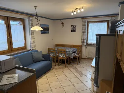 a living room with a blue couch and a table at Appartamento Star Begn - Piano Terra in Soraga