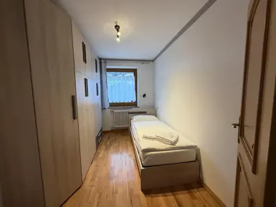 a small room with a bed and a window at Appartamento Star Begn - Piano Terra in Soraga
