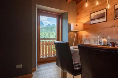 a room with a table and a window with a view at Olympic Comfy Trimestate Ampezzo s Flat in San Vito di Cadore