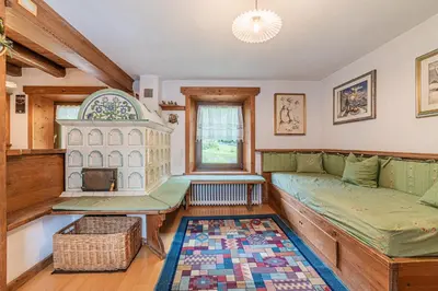 a kitchen with wooden cabinets and a rug at Da La Auri in Canale dʼAgordo