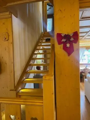 a wooden staircase with a red bow on a wall at Chalet Luxury Pelmo in San Vito di Cadore