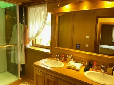 a bathroom with two sinks and a mirror and a shower at Chalet Luxury Pelmo in San Vito di Cadore