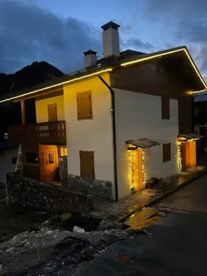 a white house with lights in front of it at Chalet Luxury Pelmo in San Vito di Cadore