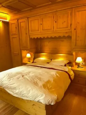 a bedroom with a large bed with two lamps at Chalet Luxury Pelmo in San Vito di Cadore