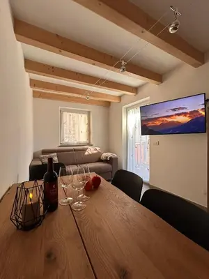 a dining room with a table with wine glasses on it at Alpen Lodge Predazzo in Predazzo