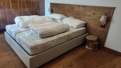 a bed with white sheets and pillows on it at 70 sqm apartment in Moena in Moena