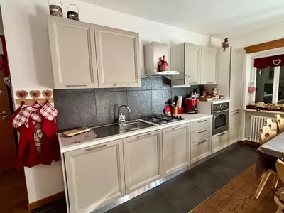a kitchen with white cabinets and a sink at 70 sqm apartment in Moena in Moena