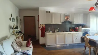 a kitchen with white cabinets and a white couch at 70 sqm apartment in Moena in Moena