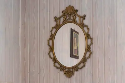 a mirror on a wall with a picture in it at Casa tipica nelle Dolomiti Trentine in Mezzano