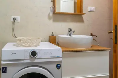 a bathroom with a washing machine and a sink at Casa tipica nelle Dolomiti Trentine in Mezzano
