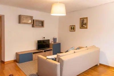 a living room with a couch and a tv at Casa tipica nelle Dolomiti Trentine in Mezzano