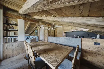 a dining room with a wooden table and chairs at Cortina Penthouse Attico Villa Diana in Pocol