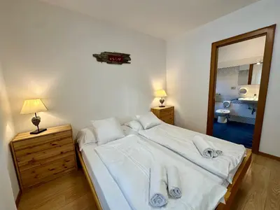 a bedroom with a bed with white sheets and towels at Central Dolomites Atelier - 3 Bedrooms in Campitello di Fassa