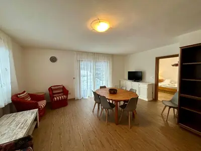 a living room with a table and chairs and a television at Central Dolomites Atelier - 3 Bedrooms in Campitello di Fassa