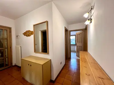 a hallway with a mirror and a wooden table at Central Dolomites Atelier - 3 Bedrooms in Campitello di Fassa