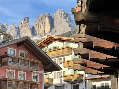 a group of buildings with mountains in the background at Central Dolomites Atelier - 3 Bedrooms in Campitello di Fassa