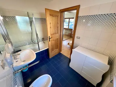 a bathroom with two sinks and a mirror at Central Dolomites Atelier - 3 Bedrooms in Campitello di Fassa