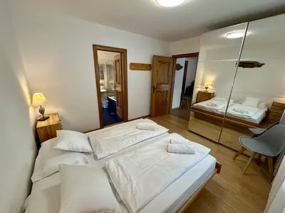 two beds in a room with a mirror at Central Dolomites Atelier - 3 Bedrooms in Campitello di Fassa