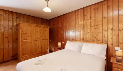 a bedroom with a bed and wood paneling at HouSmart della Difesa 72 in San Vito di Cadore