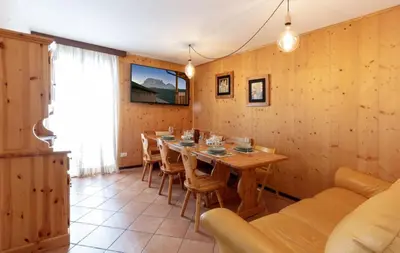 a dining room with a long table and chairs at HouSmart della Difesa 72 in San Vito di Cadore