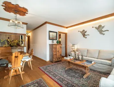 a kitchen and living room with a table in a room at Cianderies Cozy Apartment R&R in Cortina dʼAmpezzo