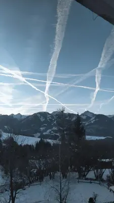 a group of contrails in the sky over a snowy mountain at Il sole di Varena in Varena