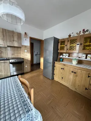 a kitchen with wooden cabinets and a table in it at Il sole di Varena in Varena