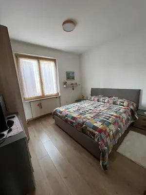 a bedroom with a bed with a quilt on it at Il sole di Varena in Varena