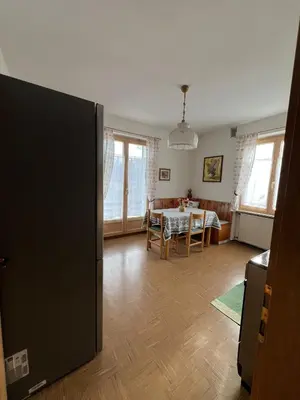 a living room with a table and a dining room at Il sole di Varena in Varena