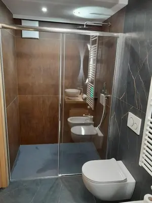 a bathroom with a shower with a toilet and a sink at Casa Zena in Tesero
