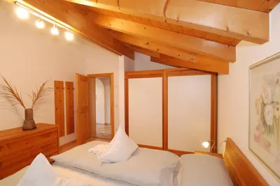 a bedroom with two beds and a large window at Ferienwohnung BERGKLANG in Nova Ponente