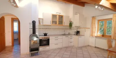 a kitchen with a stove top oven in a room at Ferienwohnung BERGKLANG in Nova Ponente