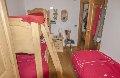a bedroom with a bunk bed with a red blanket at Ca Tambres dimora nelle Dolomiti in San Vito di Cadore