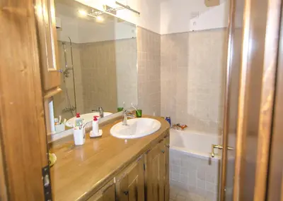 a bathroom with a sink and a mirror and a tub at Ca Tambres dimora nelle Dolomiti in San Vito di Cadore