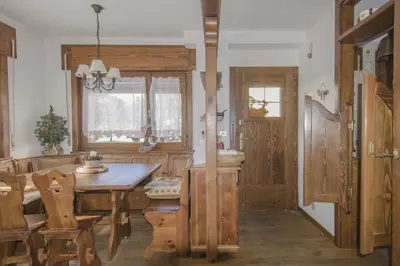 a dining room with a wooden table and chairs at Ca Tambres dimora nelle Dolomiti in San Vito di Cadore