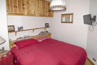 a bedroom with a bed with a red blanket at Ca Tambres dimora nelle Dolomiti in San Vito di Cadore