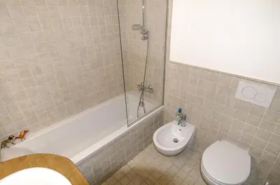 a bathroom with a toilet and a tub and a sink at Ca Tambres dimora nelle Dolomiti in San Vito di Cadore