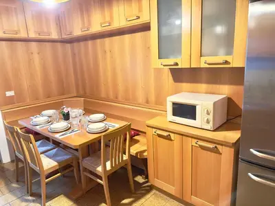 a small kitchen with a table and a microwave at Casa Cortina 3 camere da letto e parcheggio in Cortina dʼAmpezzo