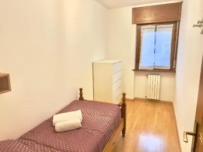 a small bedroom with a bed and a window at Casa Cortina 3 camere da letto e parcheggio in Cortina dʼAmpezzo