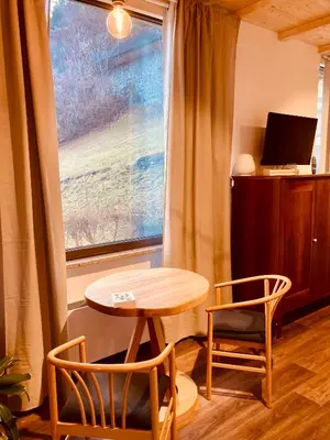 a table and two chairs in a room with a window at primiero-suite 45mq in Transacqua