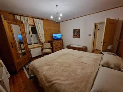a bedroom with a large bed and a television at Appartamento Lorena in Rocca Pietore