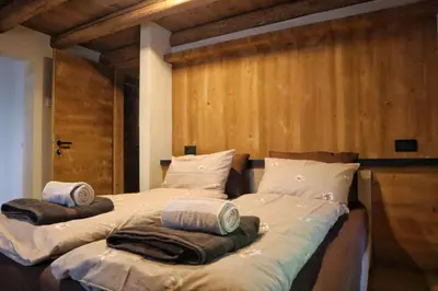 a bedroom with a bed and a dresser and a window at Ciesa Le Crepedele Miniappartamento Zenabona in Sottoguda