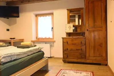 a large bed in a room with a window at Ciesa Le Crepedele Miniappartamento Zenabona in Sottoguda