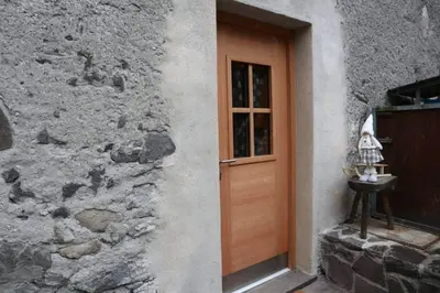 a door to a building with a stone wall at Ciesa Le Crepedele - Miniappartamento Zirum in Sottoguda