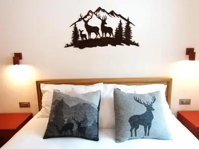 a bedroom with a bed with a deer decal on the wall at Villa Re Laurino Suite Respiro del bosco in Moena