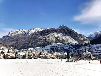 a ski resort with a mountain in the background at Villa Re Laurino Suite Respiro del bosco in Moena
