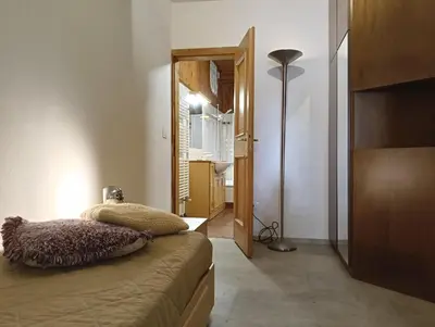 a bedroom with a bed and a lamp and a mirror at Werner's in Castello di Fiemme