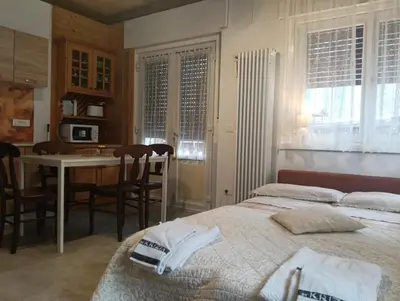 a bedroom with a bed and a kitchen with a table at Werner's in Castello di Fiemme