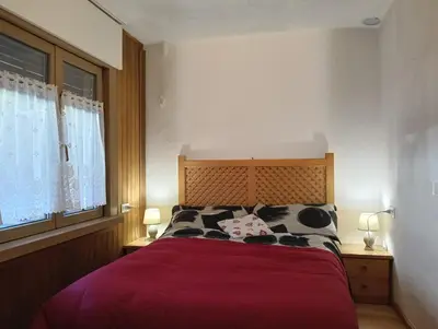 a bedroom with a red bed with two cows pillows at Werner's in Castello di Fiemme